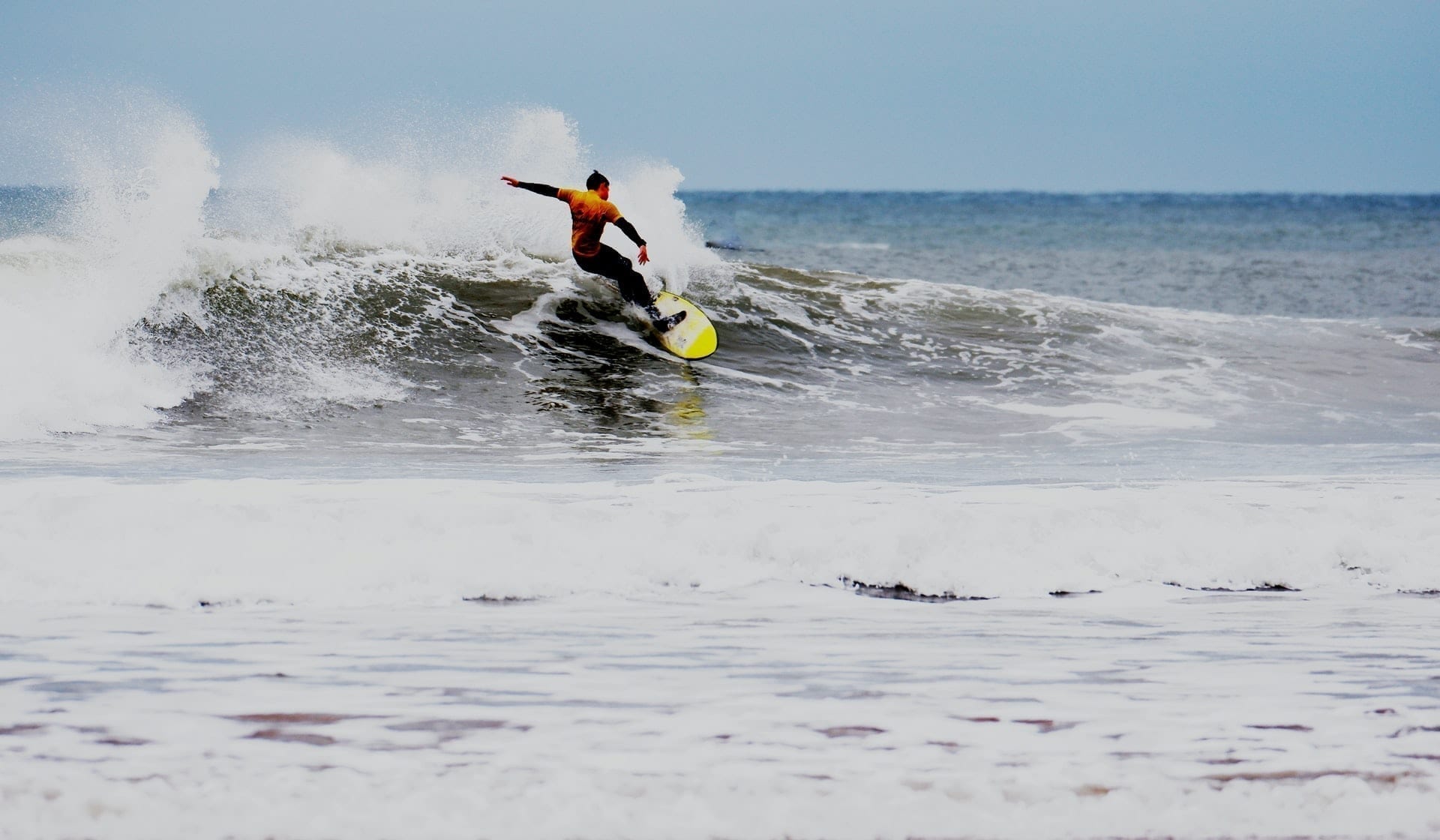 Man surfing a wave at Putsborough Beach