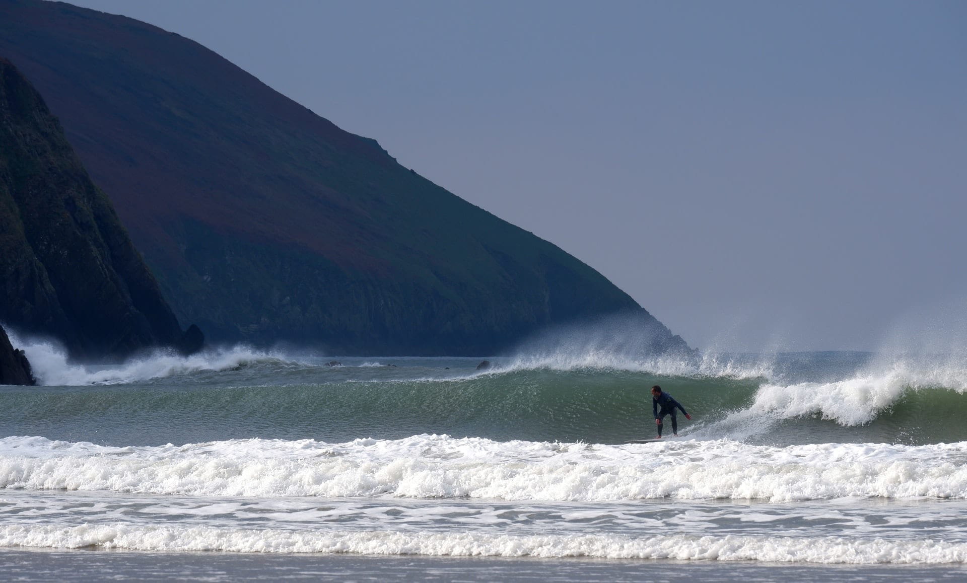 Surfer riding the waves at Putsborough beach