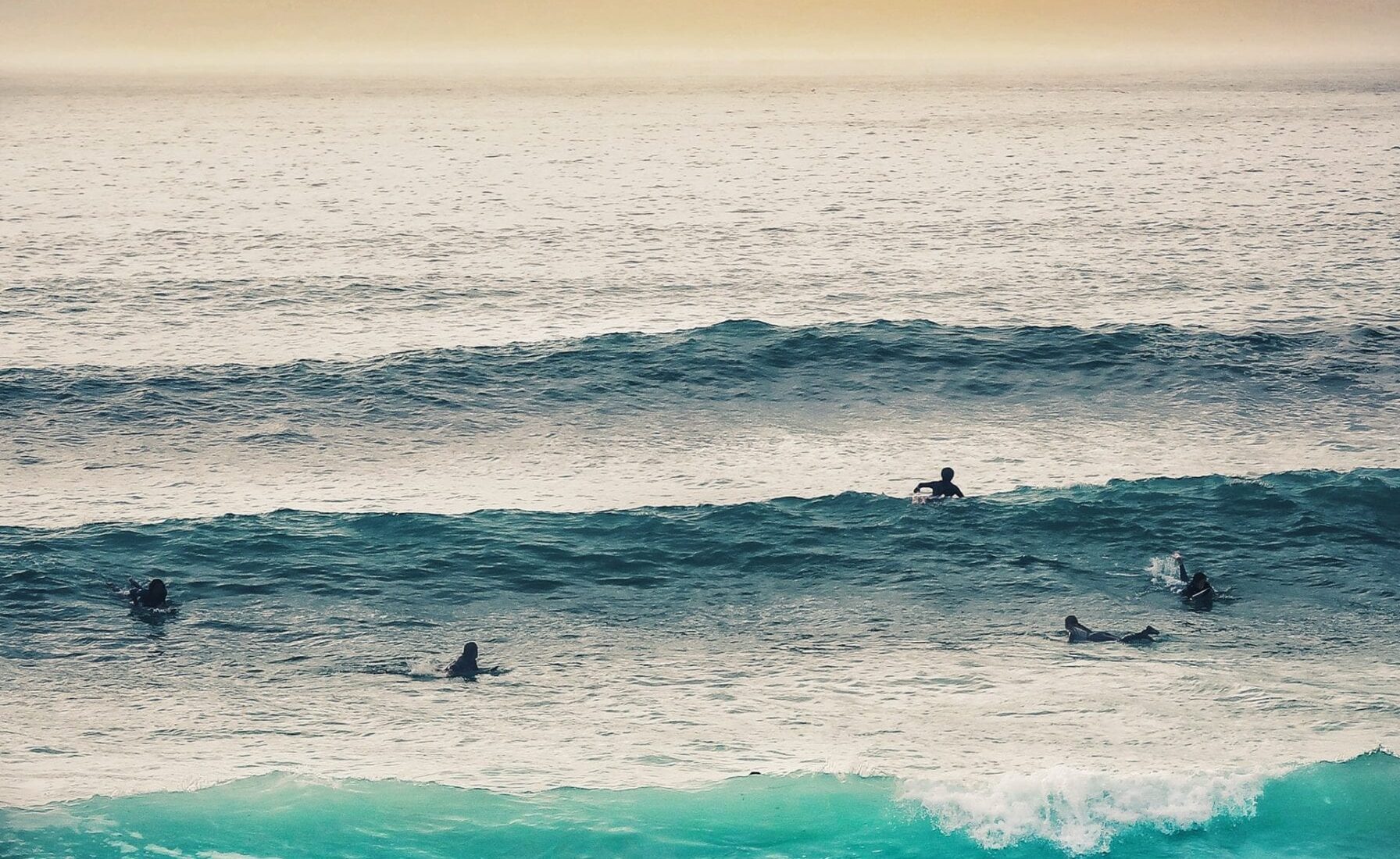 Surfers waiting to catch a wave on fistral beach in newquay, cornwall